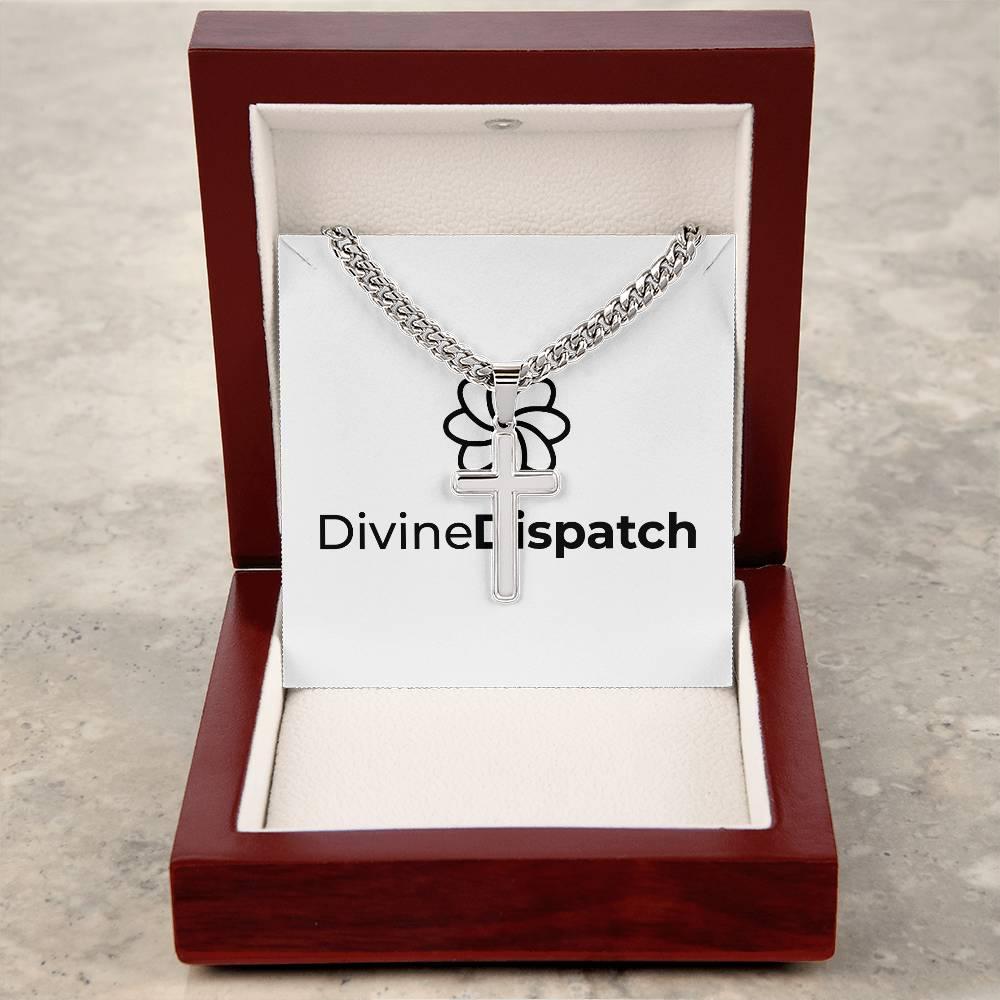 A Cuban Link Chain with an artisan cross is elegantly displayed in a wooden jewelry box labeled "Divine Dispatch," its shine contrasting beautifully against the stone background.