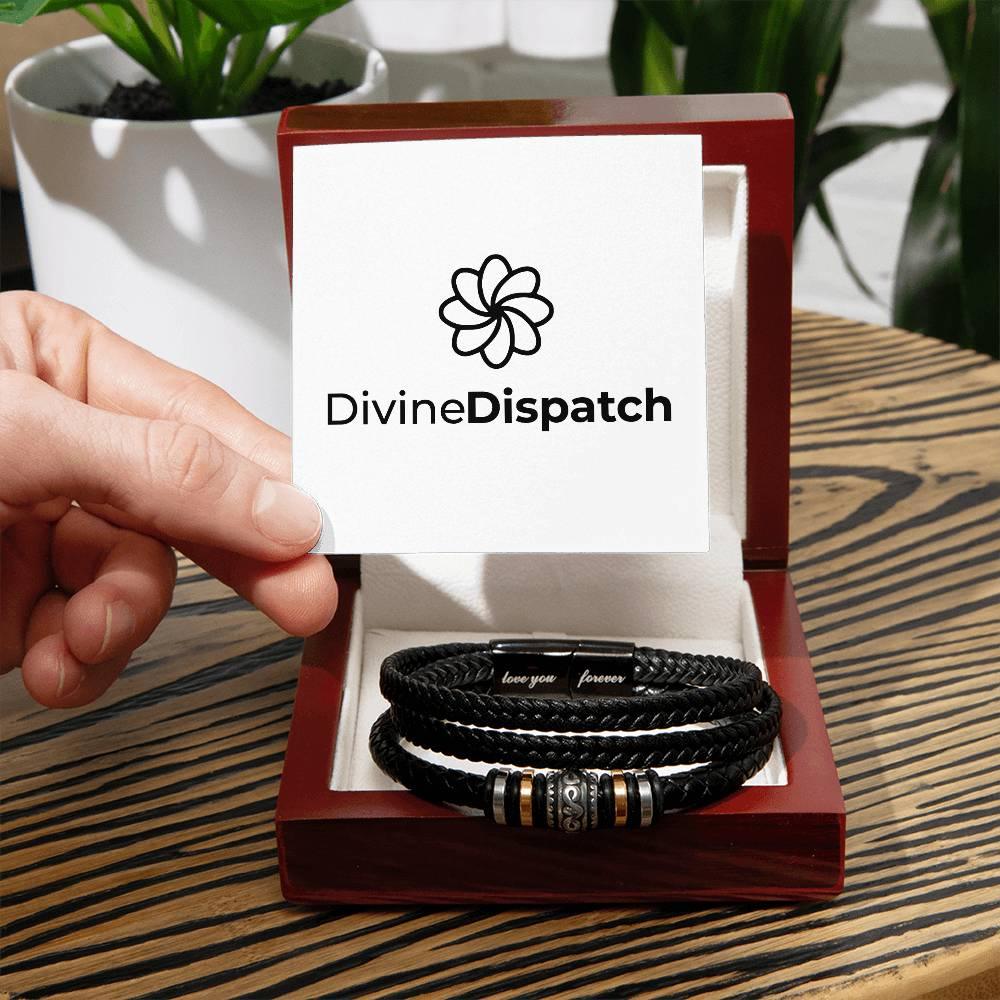 A hand holds a card from Divine Dispatch above a red box containing the "Love You Forever" men's vegan leather bracelet with metallic accents, resting on a wooden table.