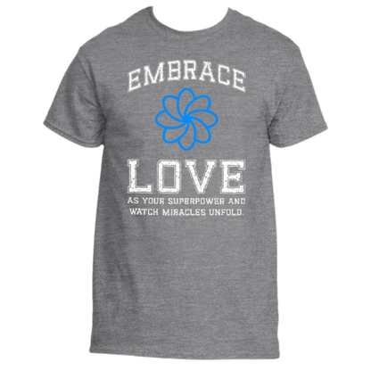 The Embrace Love T-Shirt by Divine Dispatch is a premium fabric top, showcasing white text that reads &quot;Embrace Love&quot; above and &quot;As your superpower and watch miracles unfold&quot; below a blue flower design.