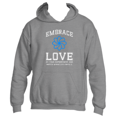 This Embrace Love Hoodie by Divine Dispatch showcases a dark heather grey base with a blue flower design and the inspiring message, &quot;Embrace Love as Your Superpower and Watch Miracles Unfold.&quot; Made from premium fabric, it is both stylish and a perfect reminder to carry positivity wherever you go.