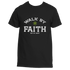 The Walk By Faith Tee by Divine Dispatch showcases a black background adorned with the uplifting message "WALK BY FAITH, NOT BY SIGHT" and is complemented by a small green four-leaf clover positioned above the word "FAITH." It&